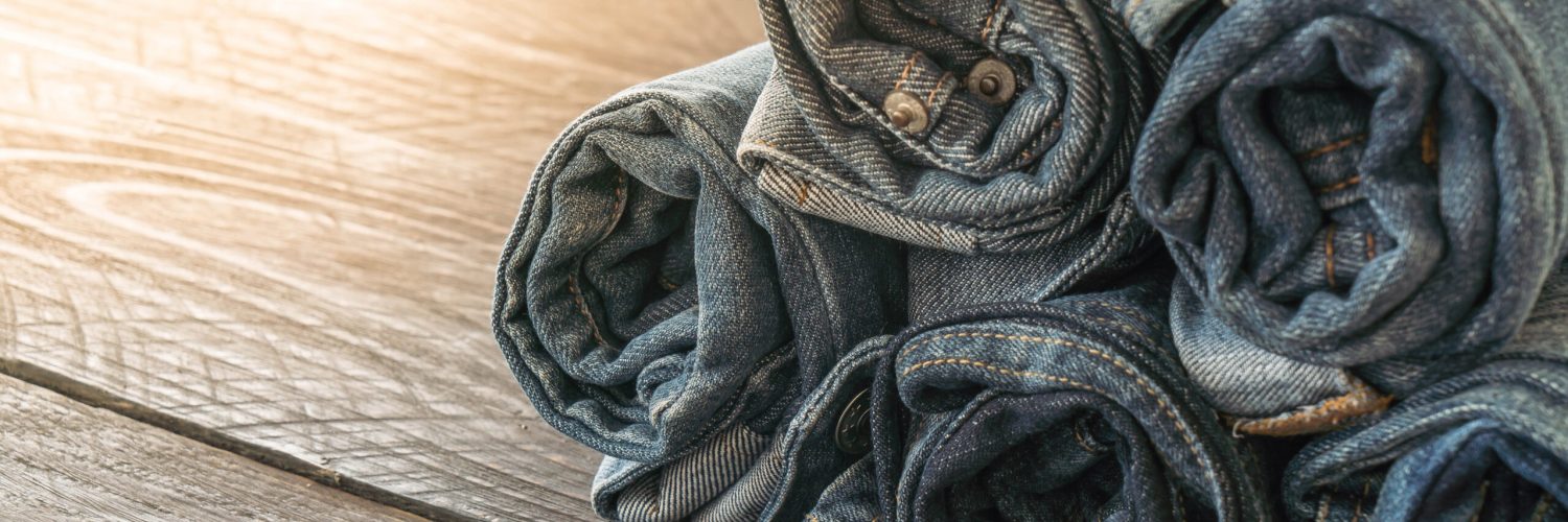 stacks of jeans clothing on wood background